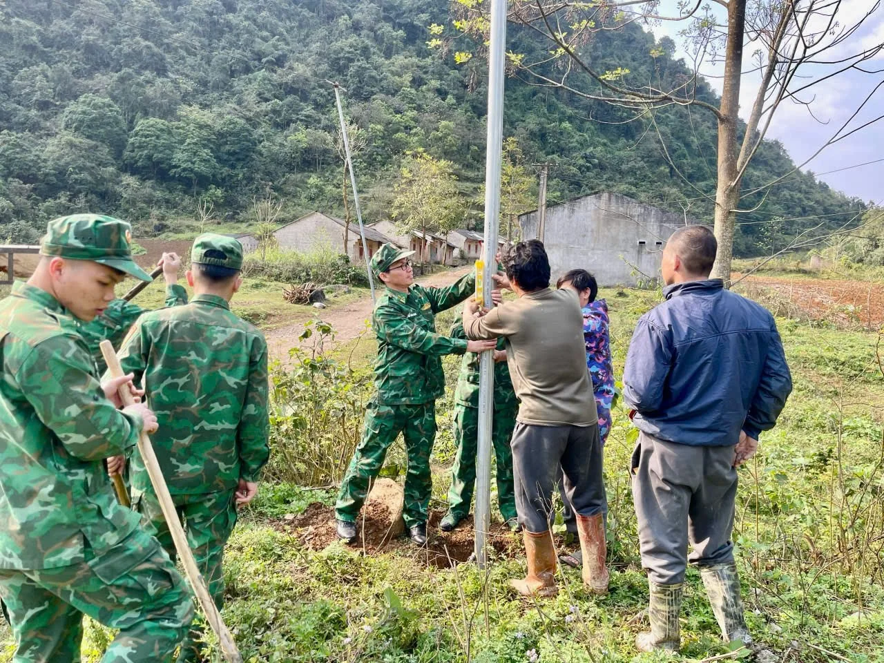 Cán bộ, chiến sĩ Đồn Biên phòng Cửa khẩu Trà Lĩnh cùng các nhà hảo tâm và người dân tham gia lắp đặt hệ thống đèn chiếu sáng.