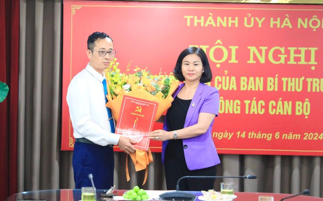 Phó Bí thư Thường trực Thành ủy Hà Nội Nguyễn Thị Tuyến trao Quyết định của Ban Bí thư Trung ương Đảng và tặng hoa chúc mừng ông Hoàng Văn Toái. Ảnh: Quang Thái