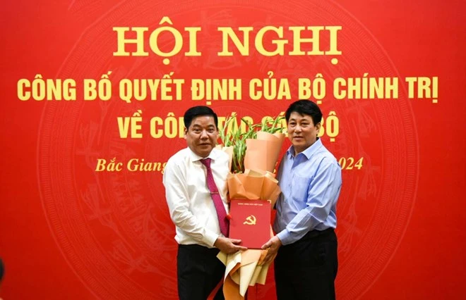 Thường trực Ban Bí thư Trung ương Đảng Lương Cường (bên phải ảnh) trao quyết định và tặng hoa chúc mừng Trung tướng Nguyễn Văn Gấu. Ảnh: Vân Trường