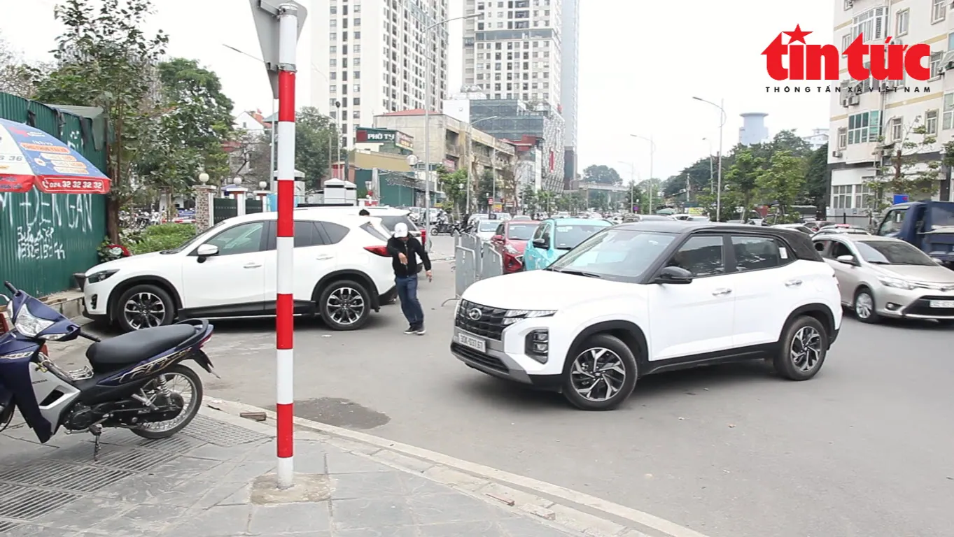 Lợi dụng tuyến đường có vỉa hè rộng và có biển "Cấm đỗ xe" cả 2 chiều, các đối tượng "cò mồi" chèo kéo, dẫn dắt người dân về đỗ ô tô trên vỉa hè để thu phí.