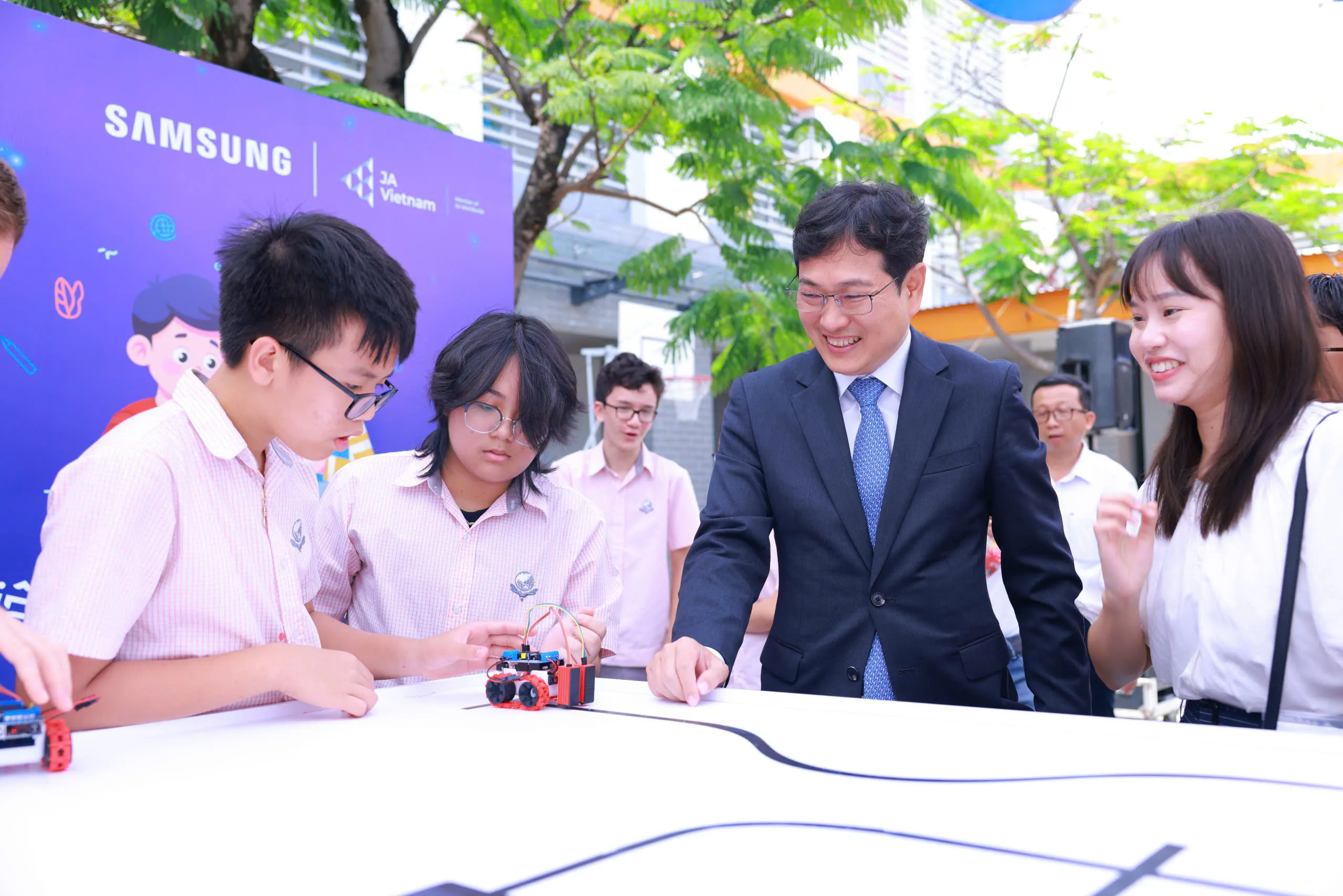 Các em học sinh tham gia hoạt động trải nghiệm sáng tạo robot bên lề sự kiện.