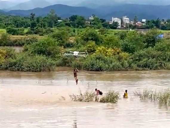 Nghẹt thở pha dùng drone hạng nặng giải cứu 2 bé mắc kẹt giữa dòng nước xiết